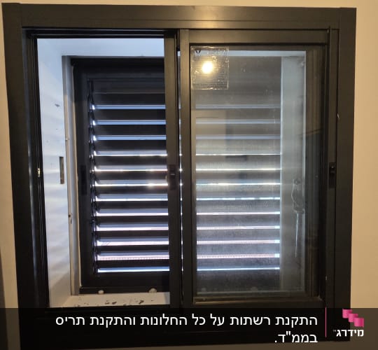 חלון אלומיניום כהה מותקן בחדר ממ"ד